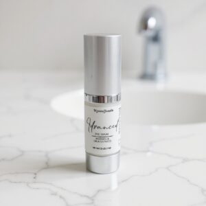 Skincare serum bottle on marble countertop.