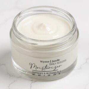 Jar of white facial moisturizer on marble.