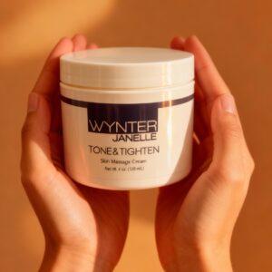 Hands holding skin massage cream container.